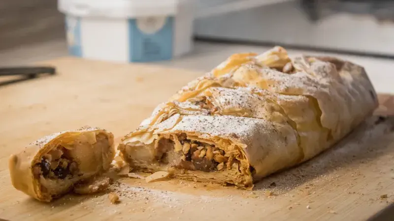 Pečený štrúdl s oříšky a ovocem na dřevěné desce