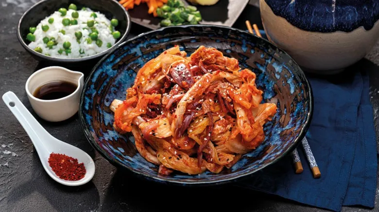 Kimchi v modrém talíři s rýží a kořením