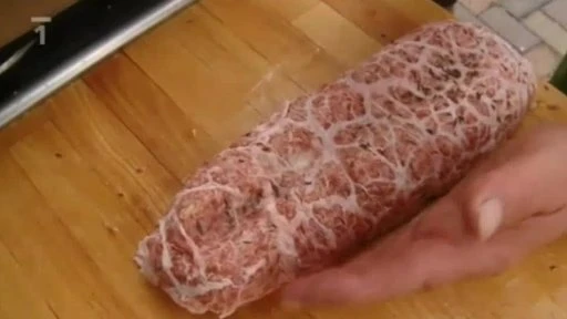 Rulka z sekaného masa v síťce na dřevěné desce