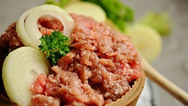 Mleté maso s cibulí a petrželí v dřevěném misku
