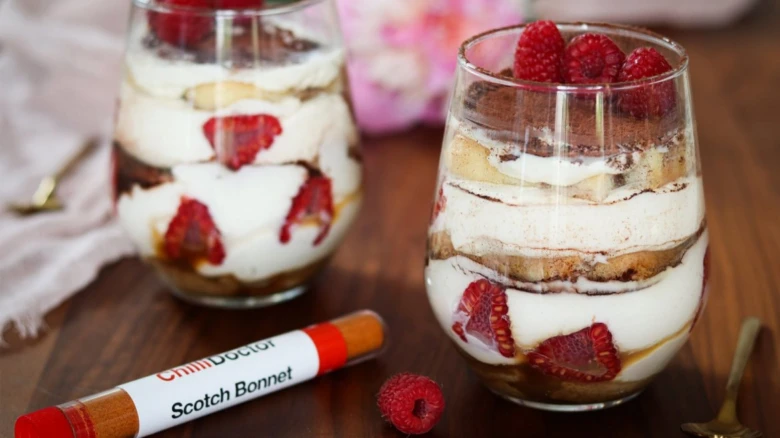 Tiramisu ve skleničkách s malinami na dřevěném stole