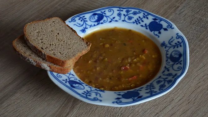 Čočková polévka v modrobílém talíři s chlebem