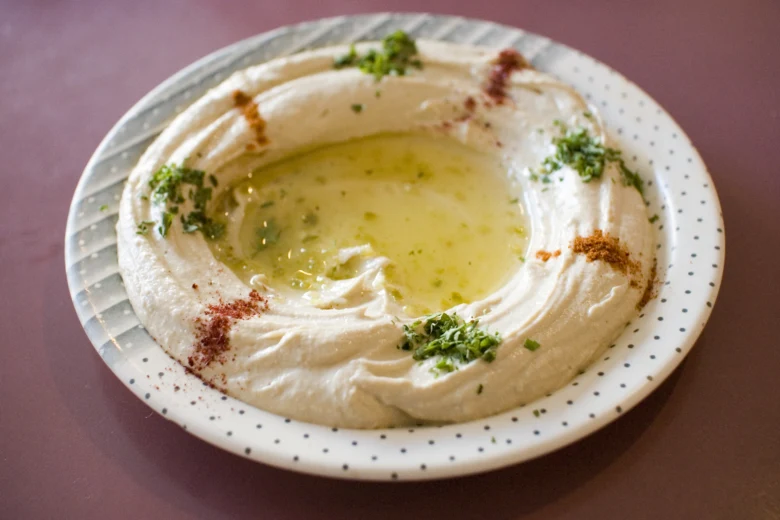 Hummus na talíři s olivovým olejem a bylinkami