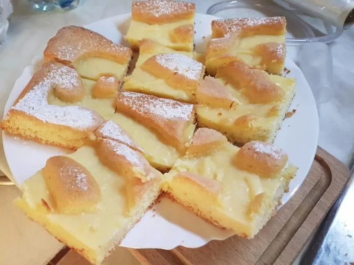 Buchta s pudinkem na talíři, posypaná cukrem