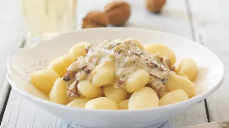 Gnocchi s houbami v krémové omáčce na bílém talíři