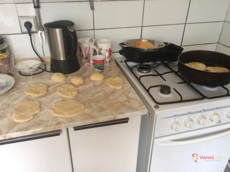 Příprava babiččiných vdolek na kuchyňské desce a vaření na pánvi
