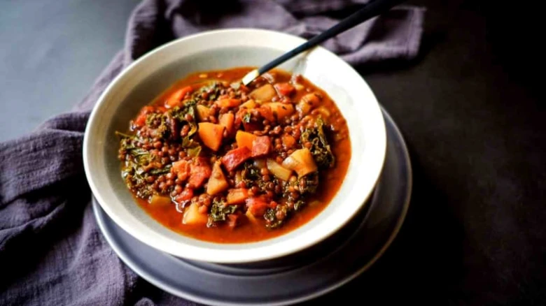 Čočková polévka s bramborami a zeleninou v bílé mísce