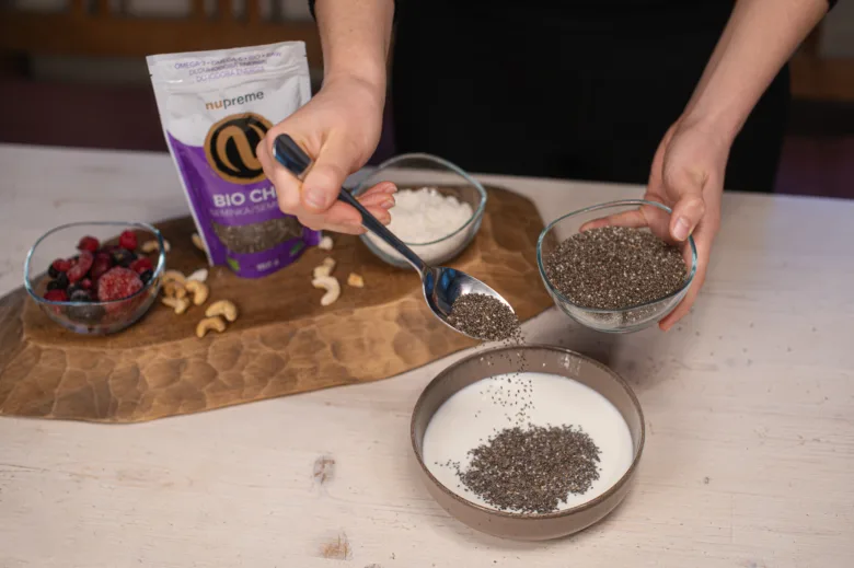 Připravování chia pudinku – přidávání semínek do mléka