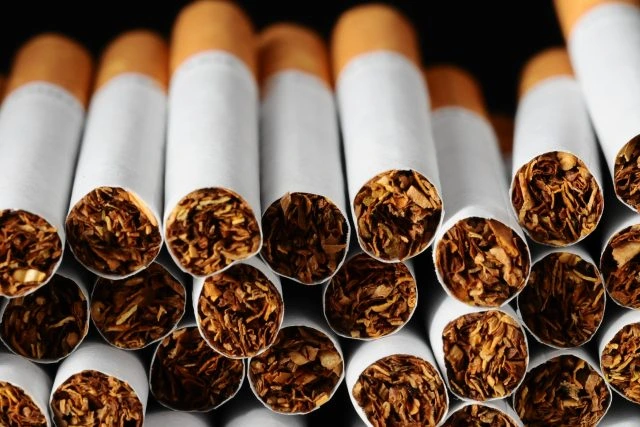 Hromada cigaret s viditelným tabákem uvnitř filtrů.