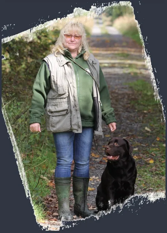 Žena s černým labradorským retrívrlem na procházce