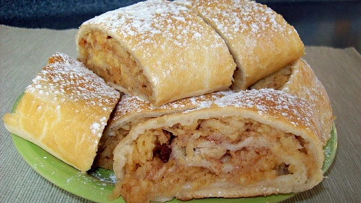 Štrúdl s jablkem na zeleném talíři, posypaný cukrem