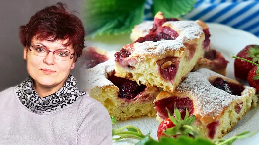 Žena vedle kousků bublaniny s jahodami a práškovým cukrem