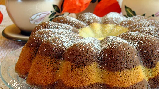 Bundtová bábovka posypaná cukrem na talíři