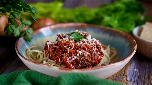 Boloňské špagety s mletým masem a parmezánem v keramickém talíři