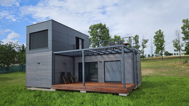 Moderní modulový dům s terasou na zeleném trávníku