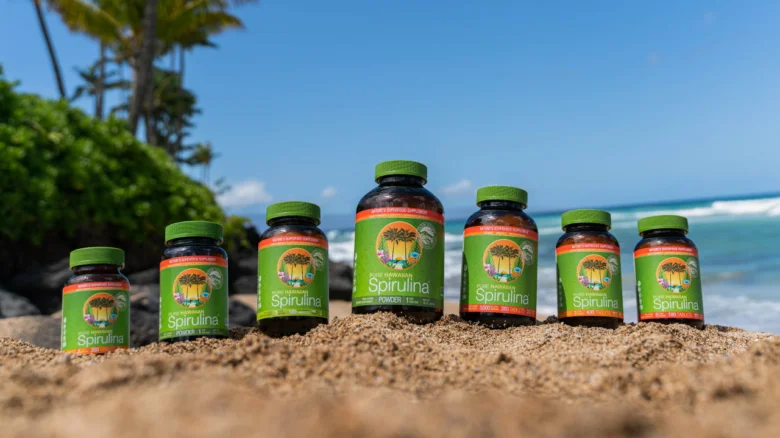 Fľaše s spirulinou na pláži u moře