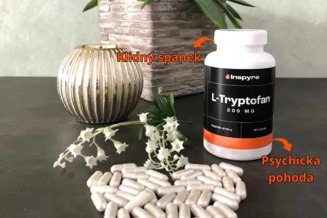 Bílá lahvička s l-tryptofanem a tobolky na tmavém povrchu.