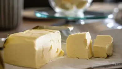 Kusy žlutého másla na papíře s rozmazaným pozadím.