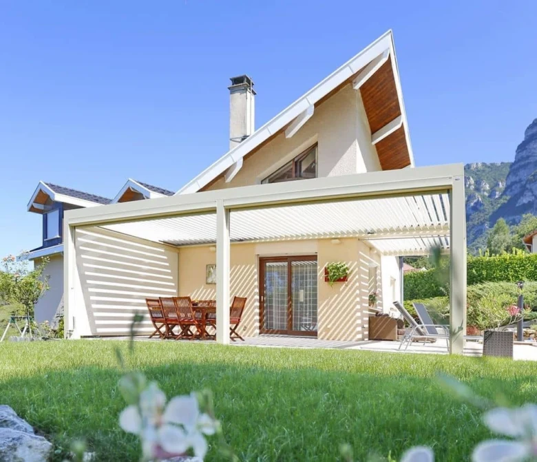 Moderní bílá pergola nad zahradním terasou s nábytkem.