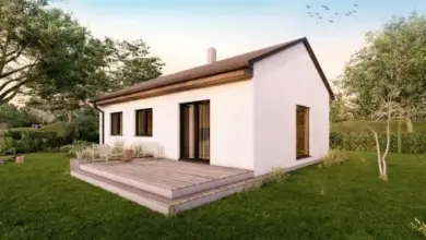 Moderní montovaný dům na klíč s dřevěnou terasou v zeleném prostředí.